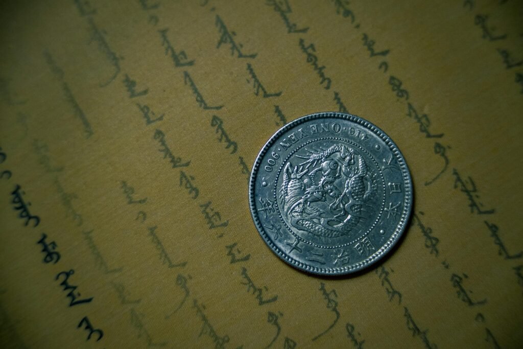 Close-up of an antique silver coin resting on vintage handwritten document.