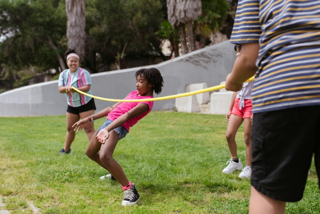 Children enjoy a fun limbo game on the grass at summer camp, promoting friendship and teamwork.