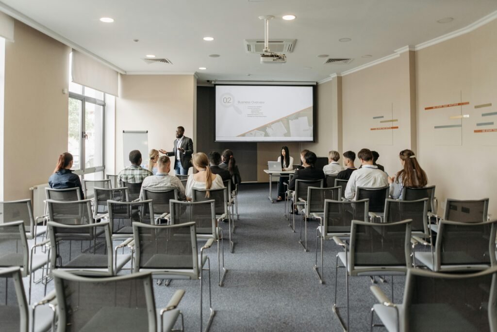 A group attending a business presentation in a modern conference room with projector.